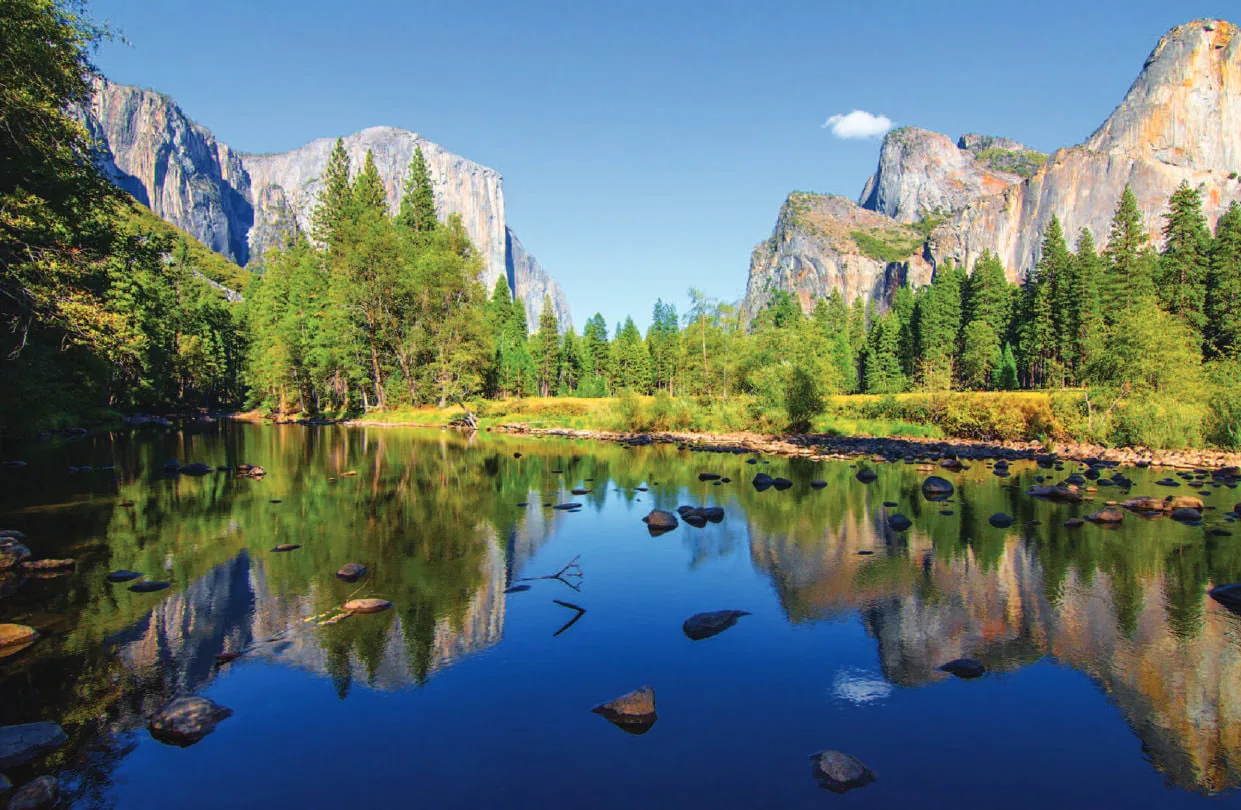 Granite cliffs reflected in a river in a valley