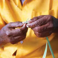 Hands weaving strips of palm leaf