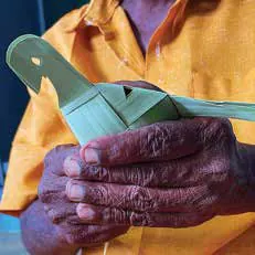 Hands holding a finished palm-leaf bird