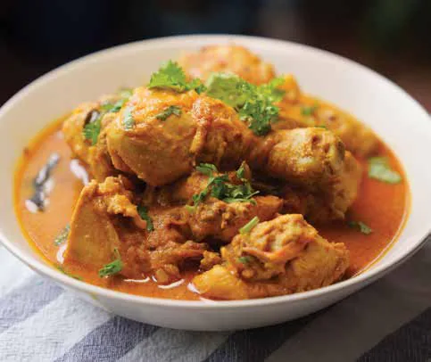 A chicken curry in a white bowl