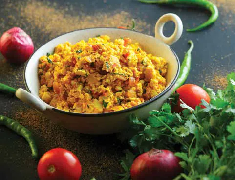 Paneer bhurji in a serving bowl with chillies and tomatoes