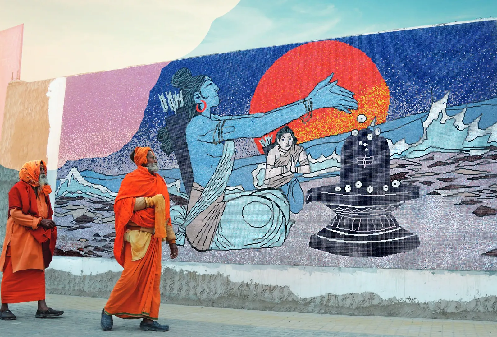 Sadhus walking past a large painted mural