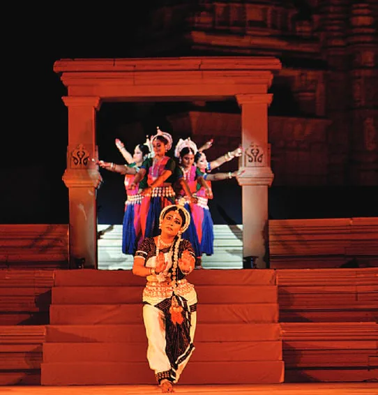 A classical dancer performing before a temple