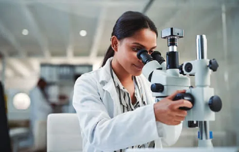 A woman scientist looking into a microscope