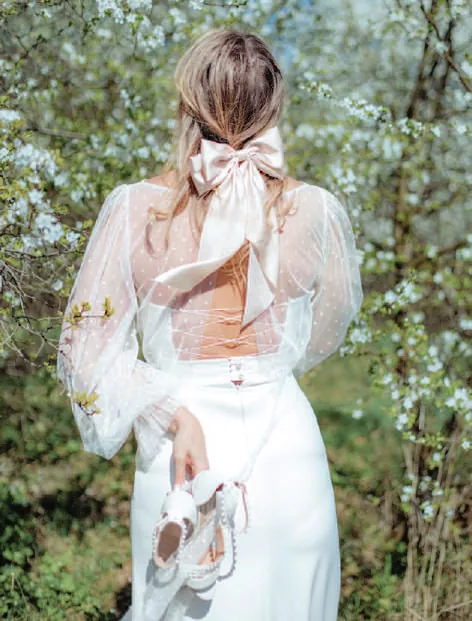 A woman in a white dress with a large bow in her hair