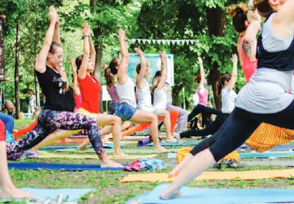 Rows of people doing yoga outdoors