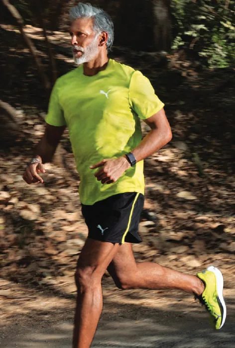 Milind Soman running on a forest trail