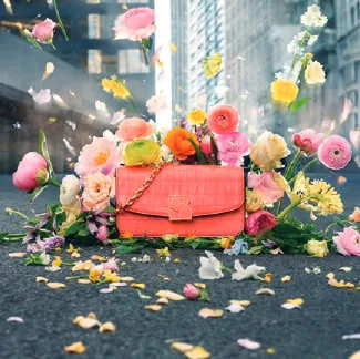 A pink handbag surrounded by flowers
