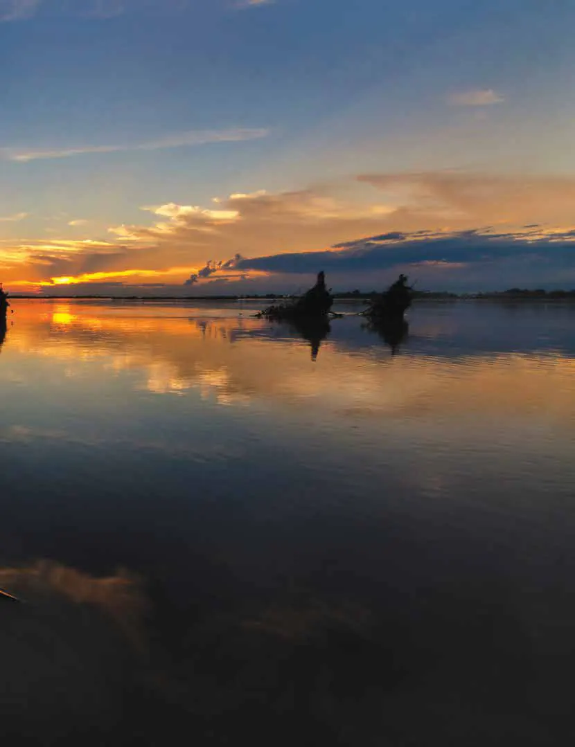 A calm river reflecting an orange sunset sky