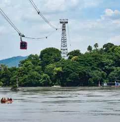 A ropeway cable car crossing above a river and a wooded island