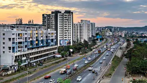 A city highway lined with high-rise buildings at dusk