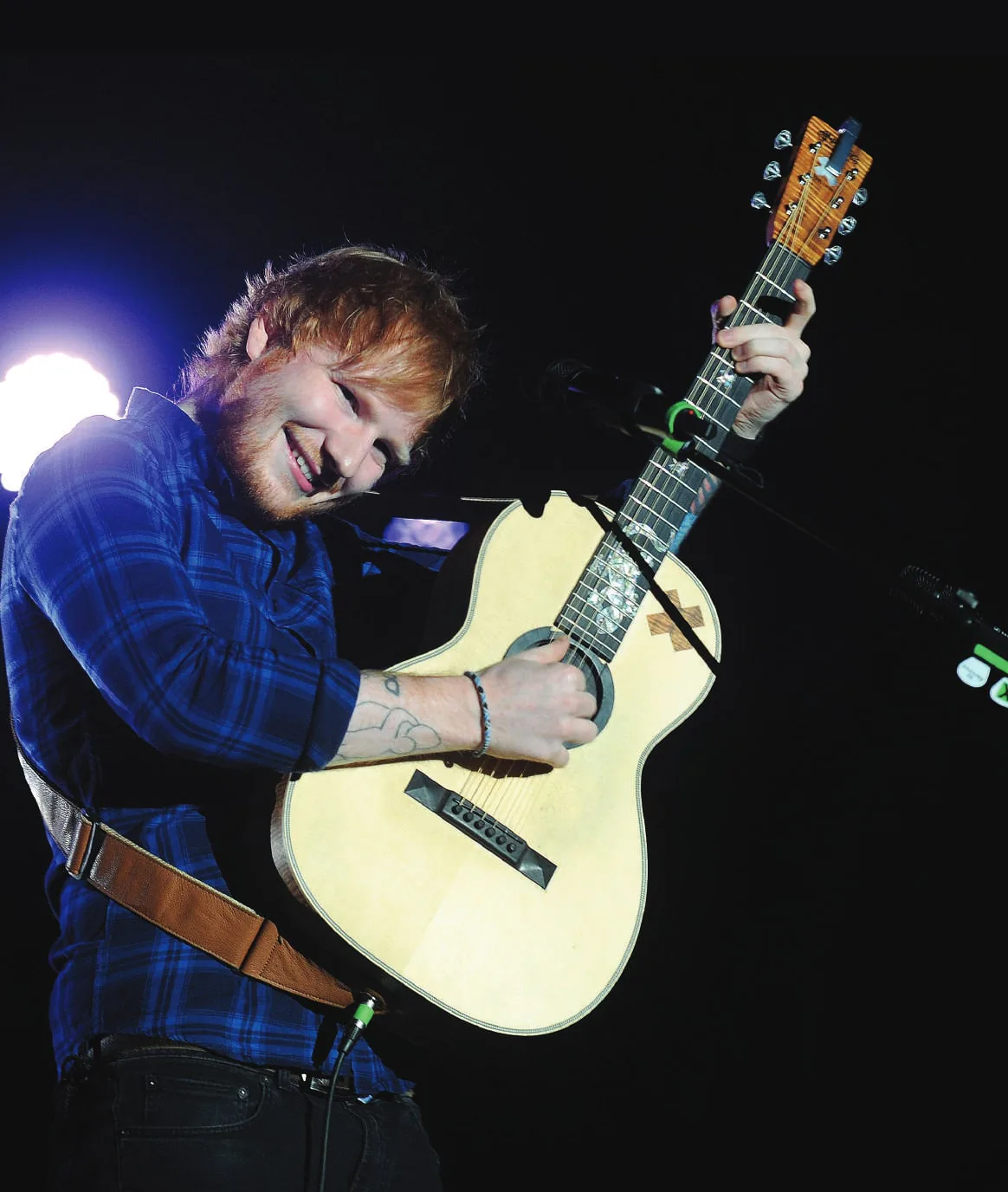 Ed Sheeran playing a guitar on stage