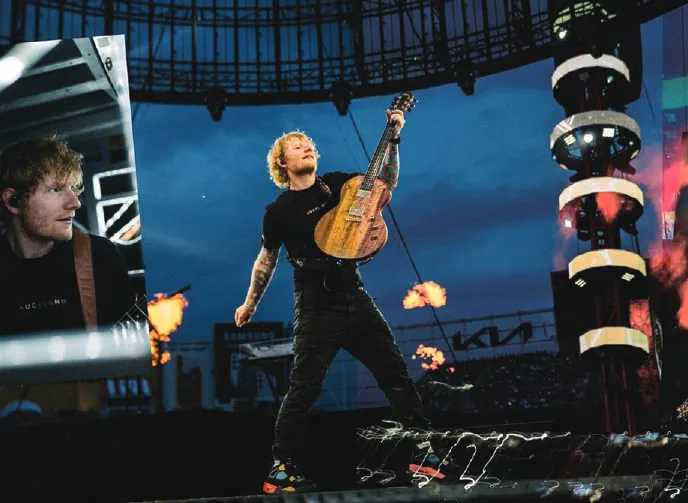Ed Sheeran playing guitar at a concert