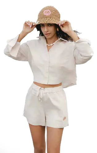 A model in a white shirt, shorts and a crochet bucket hat