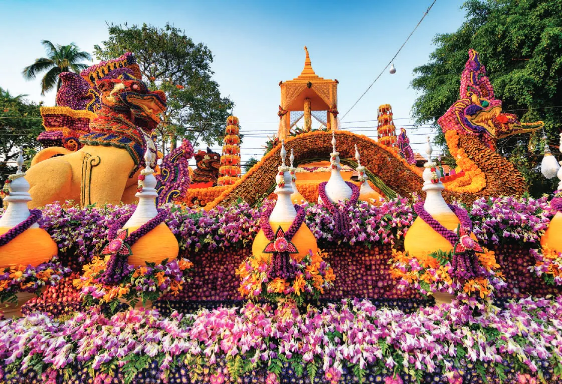 A flower-covered float in a festival parade