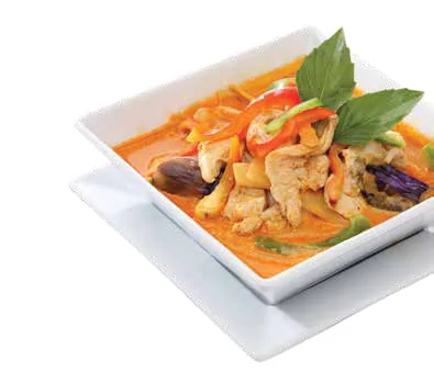 A bowl of curry with vegetables and basil
