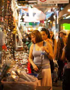 A shopper browsing a busy market stall