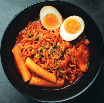 Spicy noodles with rice cakes and a boiled egg