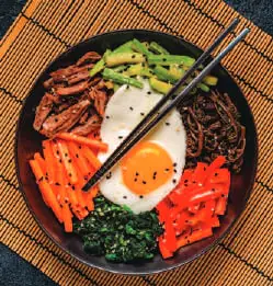 A bowl of bibimbap topped with a fried egg