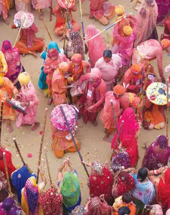 Women in bright saris holding sticks during Latmar Holi, seen from above