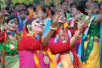 Young women smeared with colour dancing at a Holi celebration