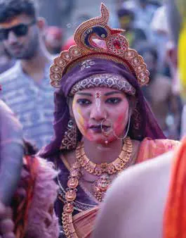 A woman in an ornate headdress with a painted face