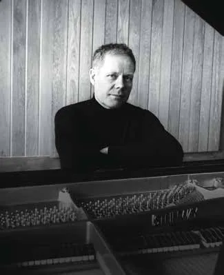Black-and-white photograph of Max Richter at a piano