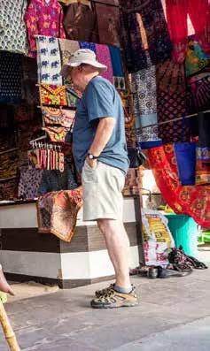 A visitor browsing textiles at a market stall