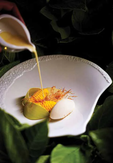 Sauce being poured over a plated dessert