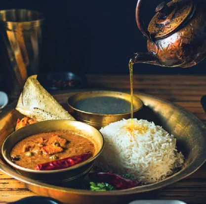 A Nepali meal of dal bhat in brass bowls