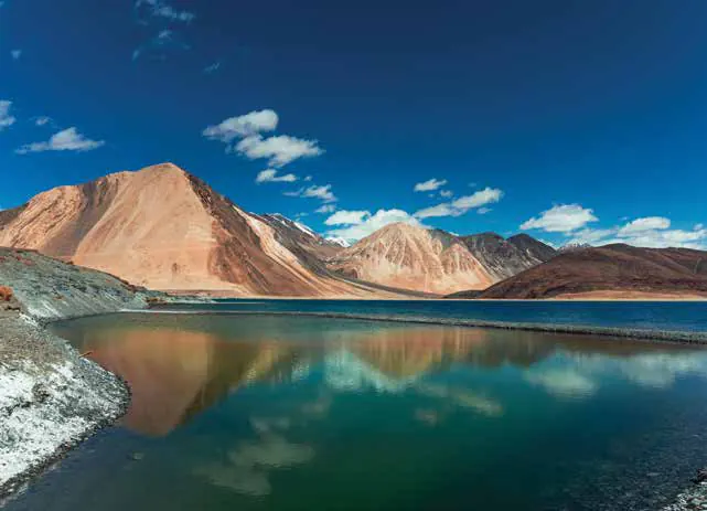 A turquoise lake beneath bare brown mountains