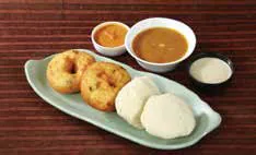 Idlis and vadas on a plate with sambar and chutney