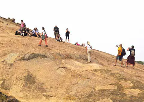 Visitors climbing a bare rocky hillside