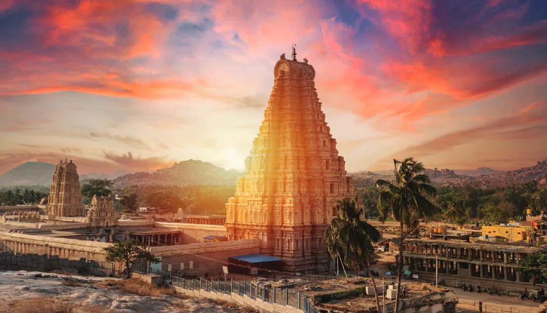 A tall temple tower in Hampi at sunset