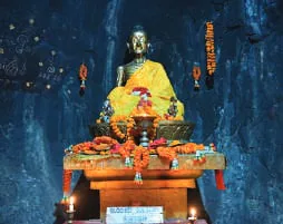 A golden Buddha shrine lit with lamps