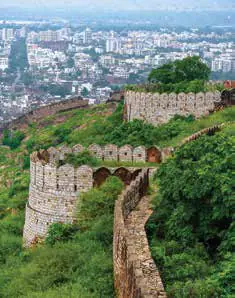 Fort walls running along a green hillside above a city