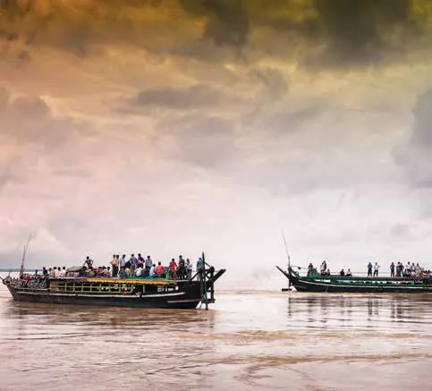 Boats on a wide river at sunset