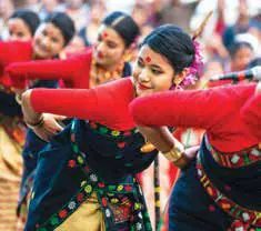 Dancers in red and white costumes performing Bihu