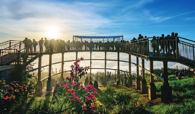 A viewpoint on a hilltop with visitors at sunrise