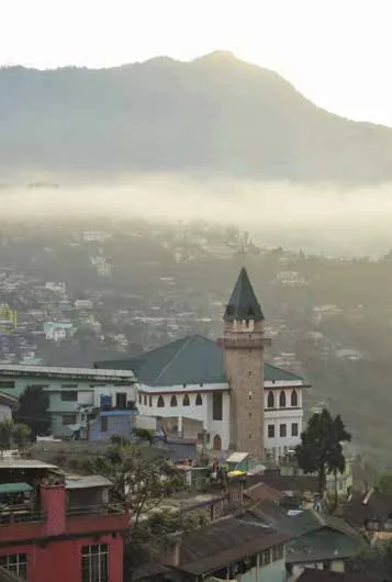 A town on a hillside below misty mountains