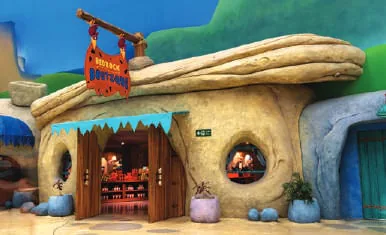 A cartoon-style building with rounded stone-look walls and a hanging sign