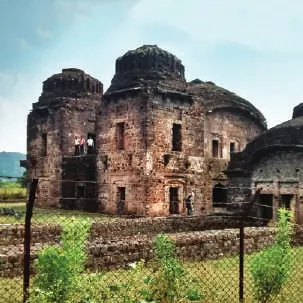 Domed stone ruins in a green field