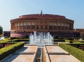 A red sandstone building with fountains