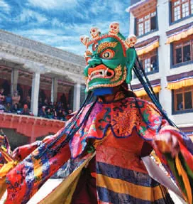A masked dancer in bright robes at a monastery festival
