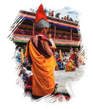 A monk in saffron robes before a monastery during a festival