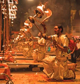 Priests holding up lamps during the evening aarti