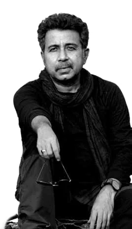 Black-and-white portrait of Pankaj Jha seated, holding sunglasses
