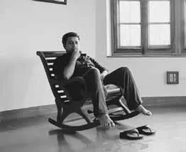 Black-and-white photograph of Pankaj Jha reclining in a rocking chair