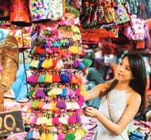 A woman browsing colourful goods at a market stall
