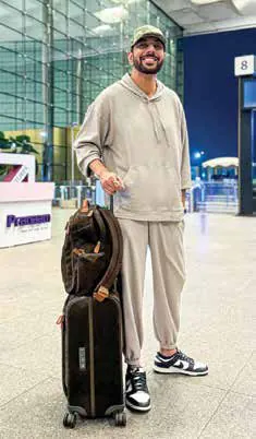Ranveer Brar standing with his luggage in an airport terminal